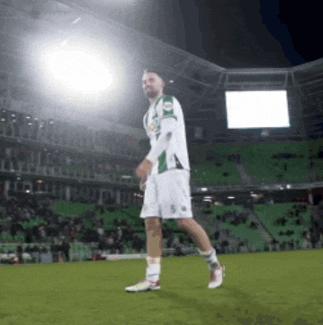 a soccer player with the number 50 on his shorts stands on the field
