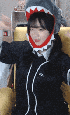 a girl wearing a shark hat and a shirt that says xo on it