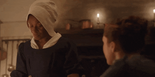 a woman wearing a white towel on her head is talking to another woman