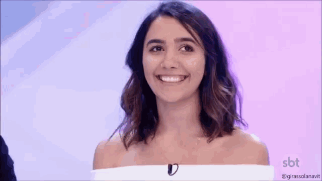 a woman is smiling and holding a small keyboard in front of her .