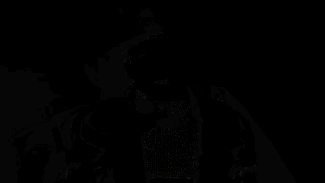 a man in a hat is lighting a cigarette