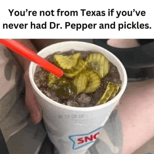 a cup of dr pepper and pickles with a straw