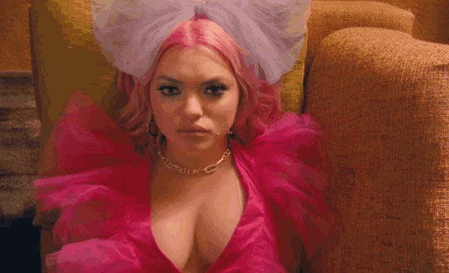 a woman with pink hair is wearing a pink dress