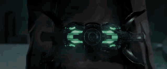 a close up of a person 's chest with a green light on it .