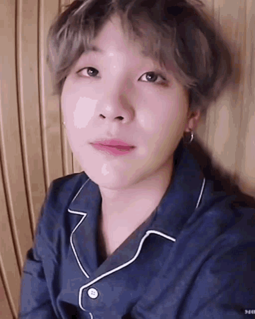 a close up of a person 's face wearing a blue pajama shirt