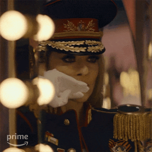 a woman in a military uniform is holding a napkin over her mouth and the word prime is on the bottom