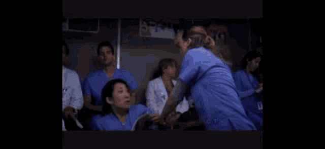 a group of nurses are standing next to each other in a room .