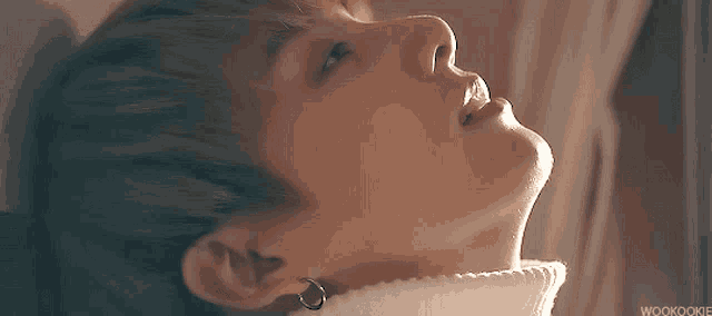 a close up of a person 's face with a white sweater on