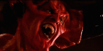 a close up of a demon 's face with its mouth open