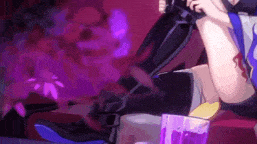 a woman is sitting on a couch holding a microphone and a cup of purple liquid .