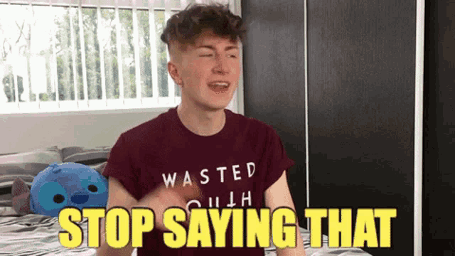 a young man wearing a wasted shirt says stop saying that in yellow letters