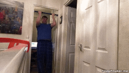 a man is hanging upside down on a pull up bar in a closet .