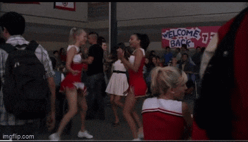 a group of cheerleaders are dancing in front of a sign that says welcome back