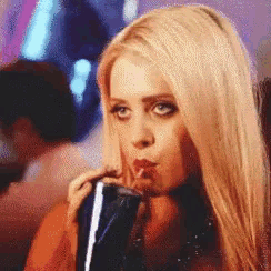 a blonde woman is drinking a soda through a straw
