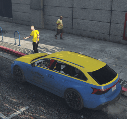 a blue and yellow downtown taxi cab is parked on the street