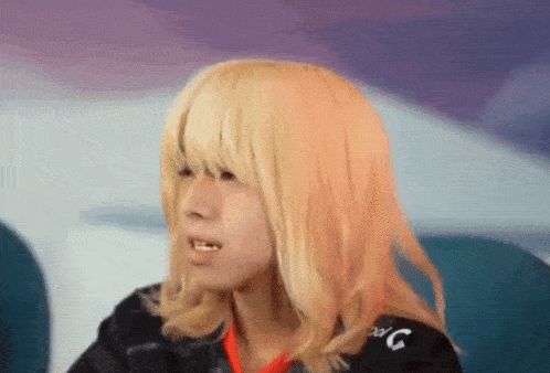 a man with long blonde hair is wearing a black shirt that says g on it