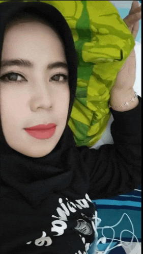 a woman wearing a hijab and a shirt that says ' samurai '