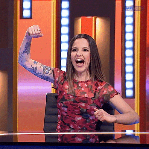 a woman with a tattoo on her arm holds her fist up