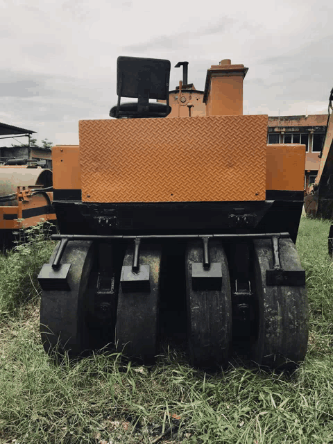 a yellow and black tractor is parked in a field