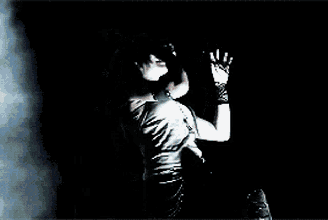a woman singing into a microphone with a smokey background