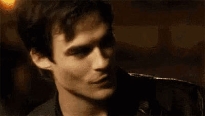 a close up of a man 's face making a funny face in a dark room .