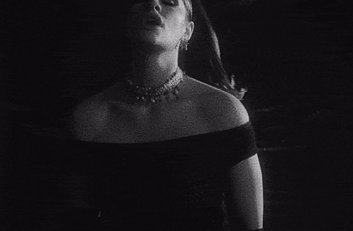 a black and white photo of a woman with a necklace