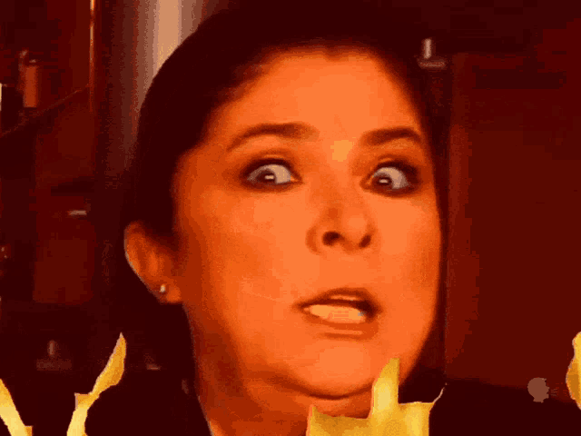 a close up of a woman 's face with flames coming out of it