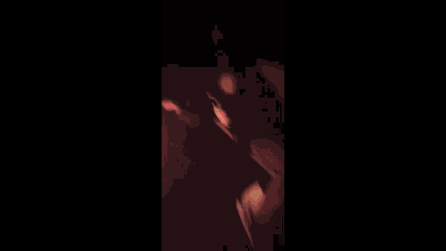 a close up of a person 's face in a dark room with a blurred background .
