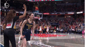 a female basketball player from the indiana team high fives her coach