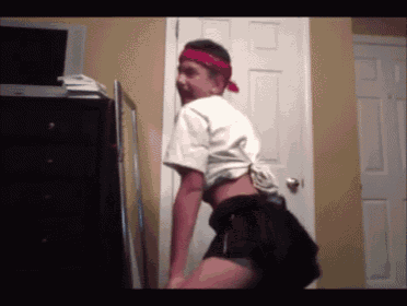 a young man wearing a red headband and shorts is dancing in a room