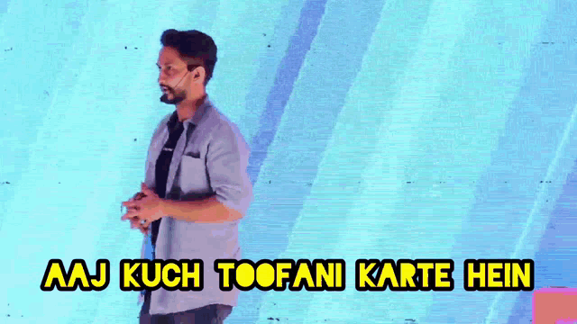 a man with a beard is standing in front of a blue background with the words aaj kuch toofani karte hein .