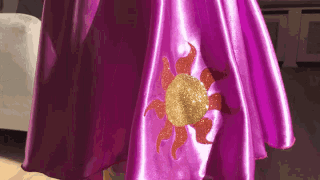 a purple dress with a sun on it