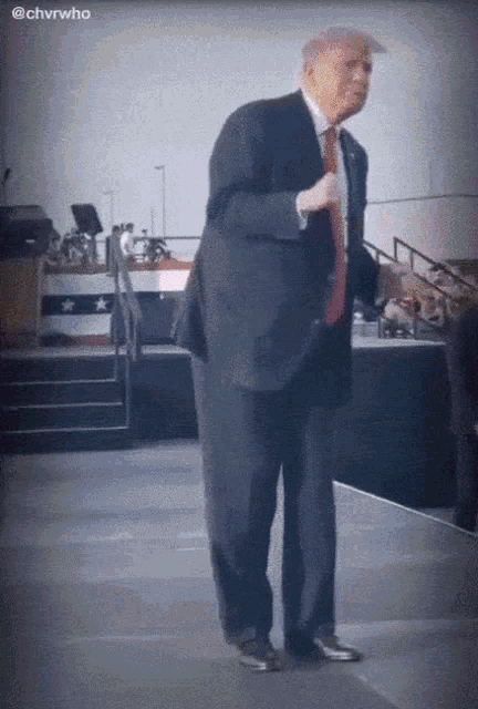 a man in a suit and tie is dancing on a stage with the hashtag @chvrwho above him