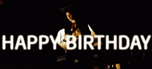 a man without a shirt is standing in front of a sign that says happy birthday .