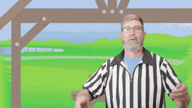 a man wearing a striped shirt is standing in front of a green field