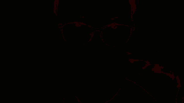 a man wearing glasses and a monster energy shirt looks at the camera