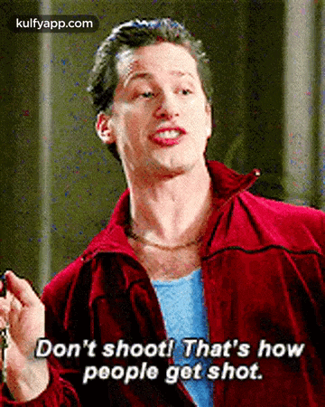 a man in a red jacket is holding a key and saying don 't shoot ! that 's how people get shot .