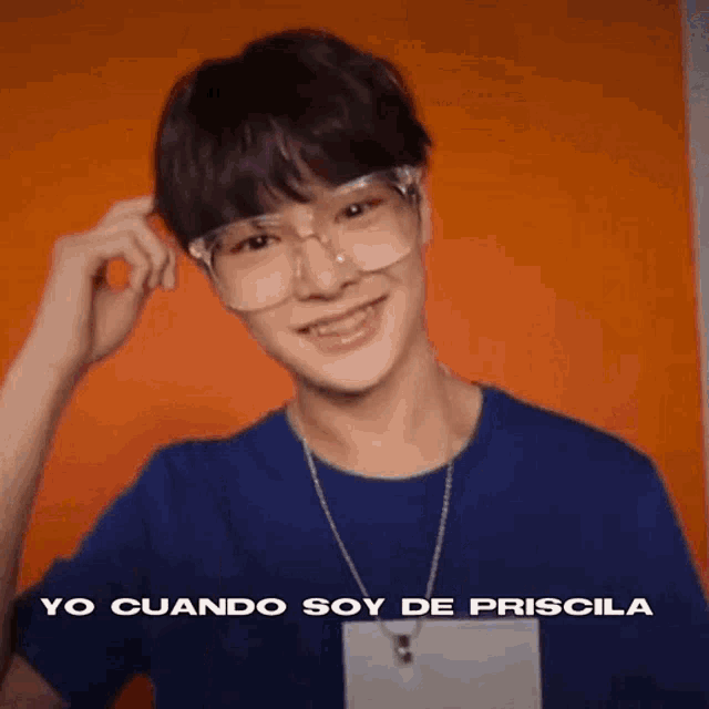 a young man wearing glasses and a blue shirt is smiling