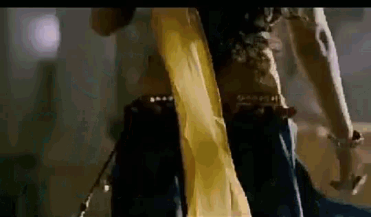 a woman in a yellow saree is dancing with a man in a black shirt .