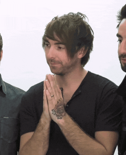 a man with a tattoo of a rose on his hand is praying