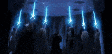 a group of people are standing in a dark room holding glowing blue swords .
