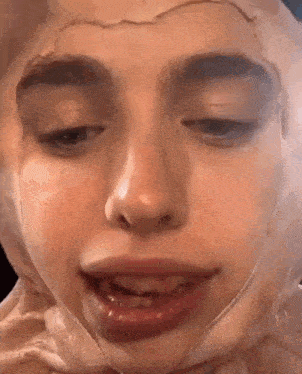 a close up of a woman 's face with a wig on it .