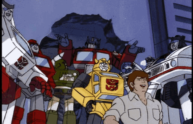 a group of transformers are standing next to a man