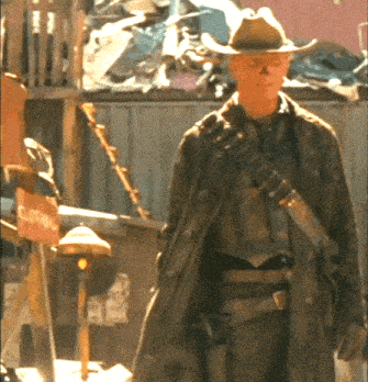 a man in a cowboy hat stands in front of a clothing store