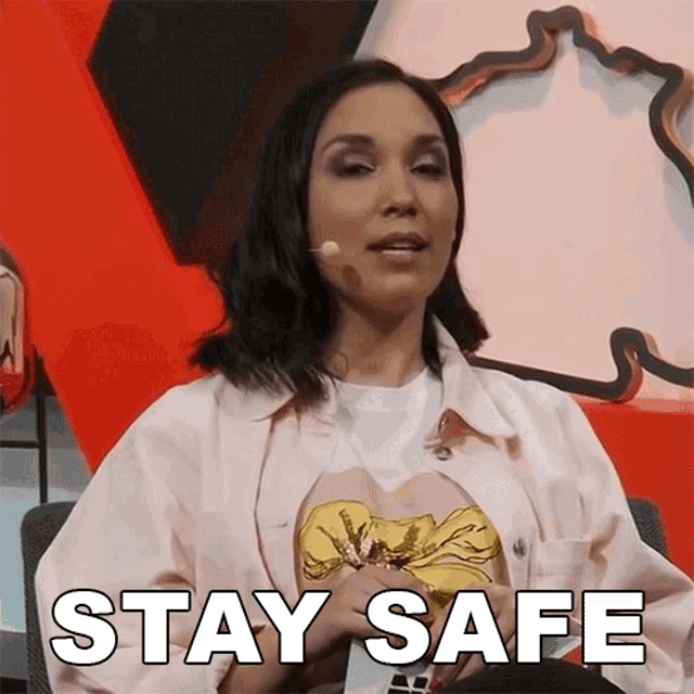 a woman in a white jacket says stay safe