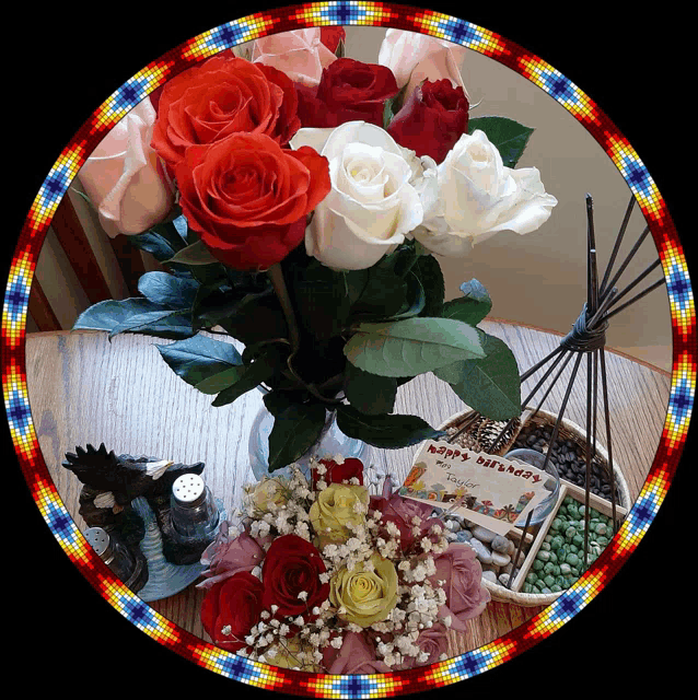 a bouquet of roses sits on a table with a happy birthday card