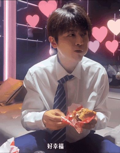 a man in a white shirt and tie is eating a burger