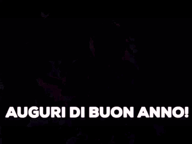 a man wearing a hat and sweater is saying auguri di buon anno .