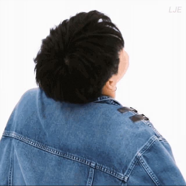 the back of a person wearing a denim jacket is shown