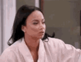 a woman in a white robe is sitting at a table .